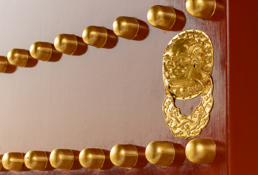 View of traditional red lacquered door with golden studs and an ornate lion head door knocker at the Forbidden City in Beijing Beijing China. View of traditional red lacquered door with golden studs and an ornate lion head door knocker at the Forbidden City in Beijing Beijing China.