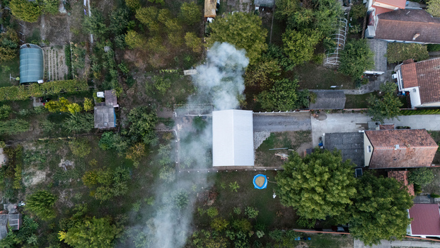 Aerial view of a residential neighborhood with houses green gardens and smoke rising from a chimney in Sremska Mitrovica Vojvodina Serbia. Aerial view of a residential neighborhood with houses green gardens and smoke rising from a chimney in Sremska Mitrovica Vojvodina Serbia.