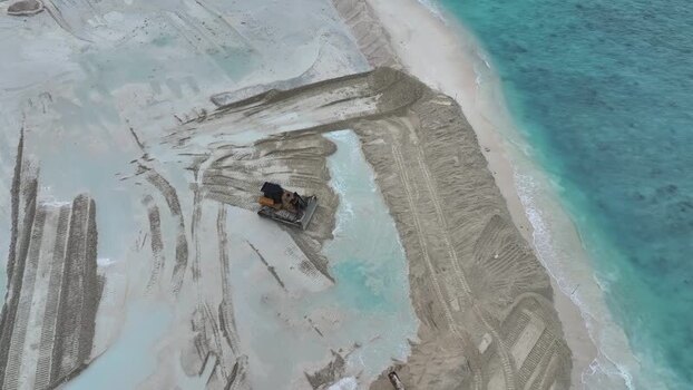 Aerial view of a bulldozer working on a beach Maldives.