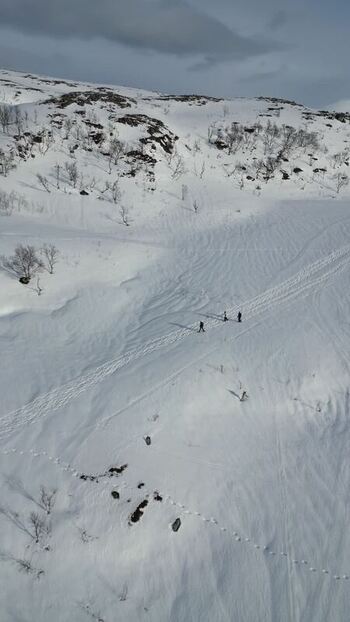 Aerial view of hikers on the snowy slopes of Kvaloya Norway.