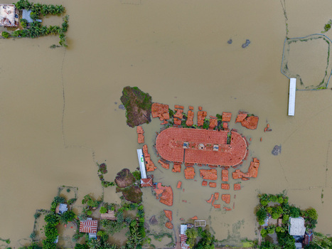 Aerial view of flooded landscape with submerged buildings and rooftops surrounded by murky floodwaters in Banshkhali Upazila Chittagong Division Bangladesh. Aerial view of flooded landscape with submerged buildings and rooftops surrounded by murky floodwaters in Banshkhali Upazila Chittagong Division Bangladesh.