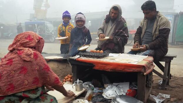 View of people eating street food at a roadside stall Bangladesh. View of people eating street food at a roadside stall Bangladesh.