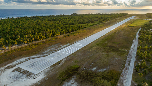 Aerial view of Tikehau Airport runway surrounded by dense palm forests and the Pacific Ocean in The Tuamotu and Gambier Islands French Polynesia. Aerial view of Tikehau Airport runway surrounded by dense palm forests and the Pacific Ocean in The Tuamotu and Gambier Islands French Polynesia.