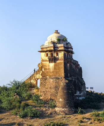 View of the historic Rohtas Fort tower with stone walls and a dome featuring a person walking up the stairs on a sunny day in Dina Punjab Pakistan. View of the historic Rohtas Fort tower with stone walls and a dome featuring a person walking up the stairs on a sunny day in Dina Punjab Pakistan.
