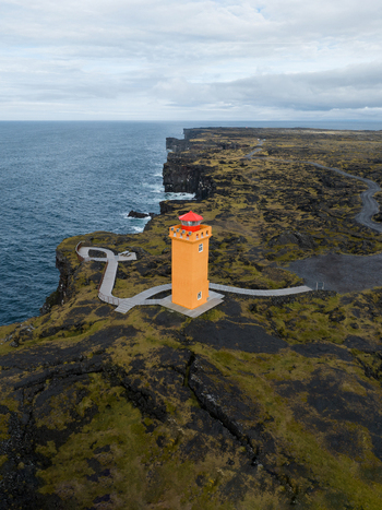Aerial view of the vibrant Svörtuloft Lighthouse standing tall against the rugged cliffs and the endless blue sea Svörtuloft Snæfellsbær Iceland. Aerial view of the vibrant Svörtuloft Lighthouse standing tall against the rugged cliffs and the endless blue sea Svörtuloft Snæfellsbær Iceland.
