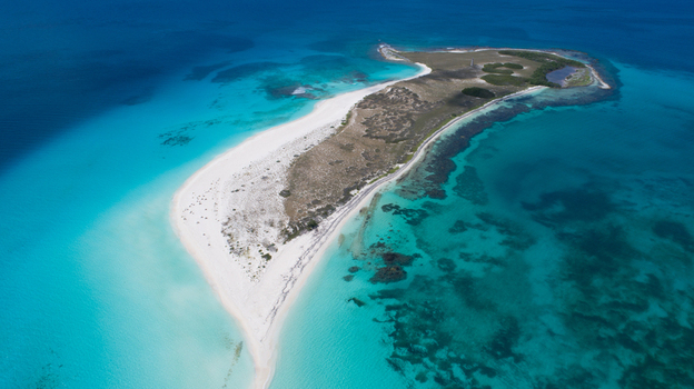Aerial view of Los Roques archipelago featuring white sand beaches turquoise Caribbean waters and coral reefs in Los Roques Dependencias Federales Venezuela. Aerial view of Los Roques archipelago featuring white sand beaches turquoise Caribbean waters and coral reefs in Los Roques Dependencias Federales Venezuela.