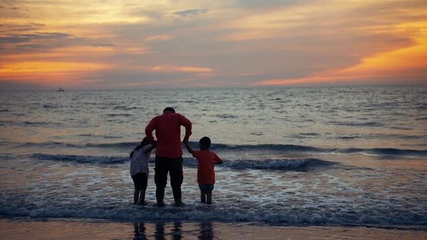 View of a father and children at sunset in Cox s Bazar Bangladesh.