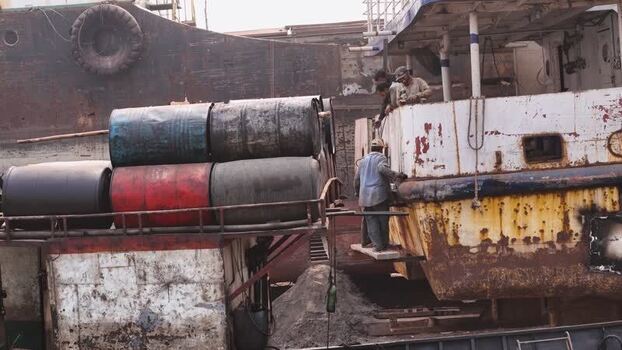 Aerial view of workers on a rusty ship with barrels Bangladesh. Aerial view of workers on a rusty ship with barrels Bangladesh.