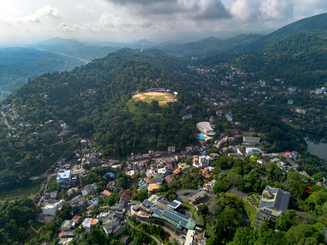 Aerial view of Kandy Lake surrounded by lush green hills dense urban development and tropical vegetation in Kandy Central Province Sri Lanka. Aerial view of Kandy Lake surrounded by lush green hills dense urban development and tropical vegetation in Kandy Central Province Sri Lanka.