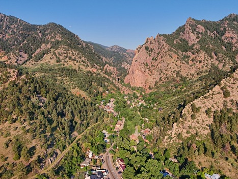 Aerial view of the scenic Eldorado Springs canyon featuring rugged rock formations lush green forests and a winding road through the small town in Eldorado Springs Colorado United States.