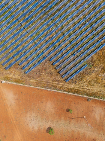 Aerial view of rows of blue solar panels in a solar farm on dry reddish brown earth in Manacor Balearic Islands Spain. Aerial view of rows of blue solar panels in a solar farm on dry reddish brown earth in Manacor Balearic Islands Spain.
