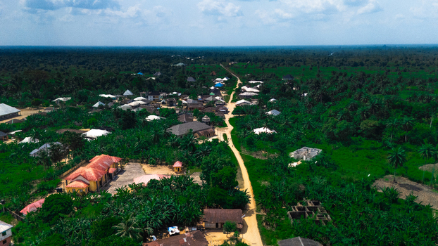 Aerial view of the rural village of Abua featuring traditional houses lush green vegetation and a dirt road winding through the landscape in Abua Rivers Nigeria. Aerial view of the rural village of Abua featuring traditional houses lush green vegetation and a dirt road winding through the landscape in Abua Rivers Nigeria.