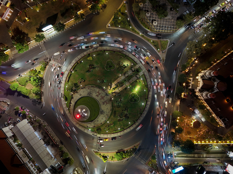 Aerial view of Tugu Muda monument and the historic Lawang Sewu building illuminated at night with traffic light trails circling the roundabout in Semarang Central Java Indonesia. Aerial view of Tugu Muda monument and the historic Lawang Sewu building illuminated at night with traffic light trails circling the roundabout in Semarang Central Java Indonesia.