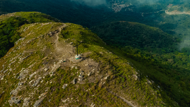 Aerial view of Mt. Gemi featuring a prominent cross at the summit surrounded by rocky terrain lush green vegetation and rolling hills in Amedzofe Volta Region Ghana. Aerial view of Mt. Gemi featuring a prominent cross at the summit surrounded by rocky terrain lush green vegetation and rolling hills in Amedzofe Volta Region Ghana.