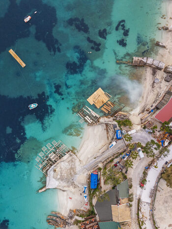 Aerial view of the turquoise waters and wooden platforms along the coastline of Ksamil Vlore County Albania. Aerial view of the turquoise waters and wooden platforms along the coastline of Ksamil Vlore County Albania.