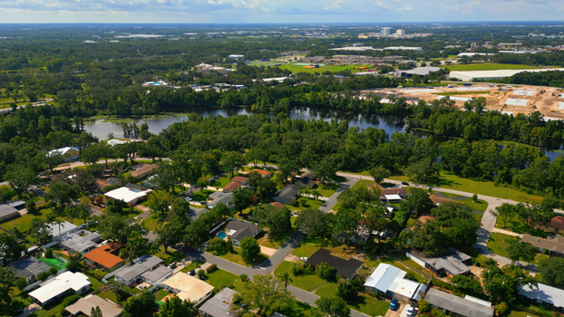 Aerial view of a residential neighborhood with lush green trees suburban houses and a winding river in Tampa Florida United States. Aerial view of a residential neighborhood with lush green trees suburban houses and a winding river in Tampa Florida United States.