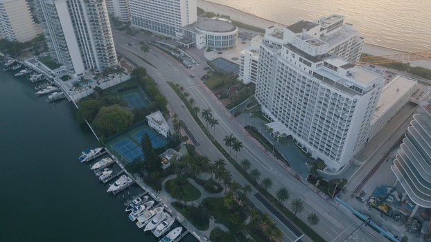 Aerial view of Miami Beach featuring luxury waterfront hotels tennis courts and a marina with docked yachts along the coastline in Miami Beach Florida United States. Aerial view of Miami Beach featuring luxury waterfront hotels tennis courts and a marina with docked yachts along the coastline in Miami Beach Florida United States.