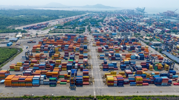 Aerial view of Jawaharlal Nehru Port Authority with rows of colorful shipping containers and industrial cranes at the harbor in Juna Sheva Maharashtra India. Aerial view of Jawaharlal Nehru Port Authority with rows of colorful shipping containers and industrial cranes at the harbor in Juna Sheva Maharashtra India.