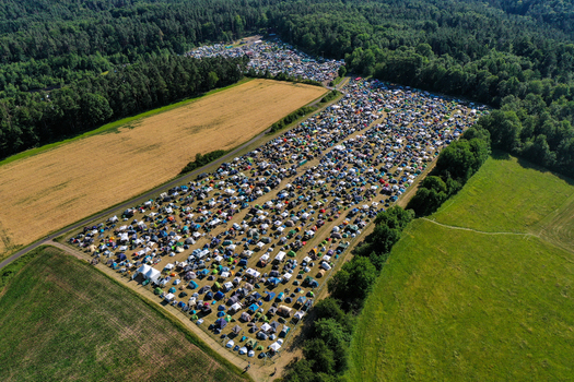 Aerial view of the Eventzentrum Strohofer Geiselwind musichall camping grounds with numerous tents surrounded by green fields and dense forest in Geiselwind Bayern Germany. Aerial view of the Eventzentrum Strohofer Geiselwind musichall camping grounds with numerous tents surrounded by green fields and dense forest in Geiselwind Bayern Germany.
