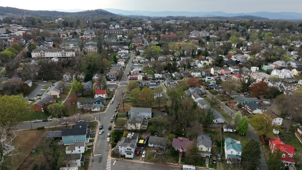 Aerial view of residential houses surrounded by spring foliage and tree lined streets in Charlottesville Virginia United States.