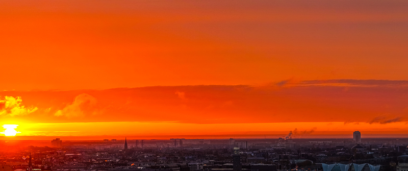 Aerial view of the Riga skyline during a vibrant sunset with glowing orange clouds and silhouettes of historic buildings in Riga Latvia. Aerial view of the Riga skyline during a vibrant sunset with glowing orange clouds and silhouettes of historic buildings in Riga Latvia.