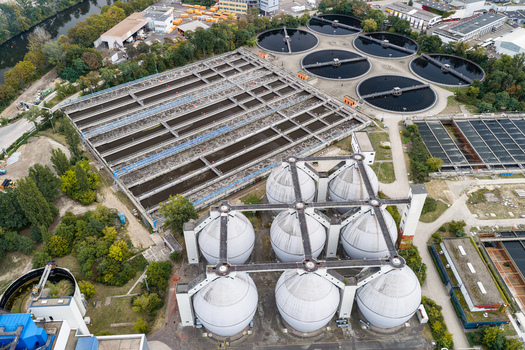 Aerial view of Klarwerk Ruhleben wastewater treatment plant with large spherical digester tanks rectangular sedimentation basins and circular clarifiers in Berlin Berlin Germany.