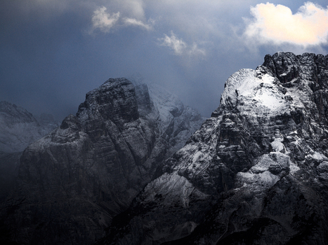 Aerial view of snow dusted peaks piercing through the clouds casting long shadows over the rugged terrain Misurina Veneto Italy. Aerial view of snow dusted peaks piercing through the clouds casting long shadows over the rugged terrain Misurina Veneto Italy.