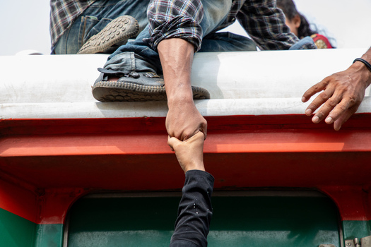 Dhaka Bangladesh 14 June 2018 View of a person helping another passenger climb onto the roof of a crowded train at Airport Railway Station. Dhaka Bangladesh 14 June 2018 View of a person helping another passenger climb onto the roof of a crowded train at Airport Railway Station.