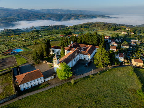 Vila Pouca da Beira Portugal 11 May 2025 Aerial view of Lam Hotel Convento do Desagravo surrounded by lush green hills and morning mist in the valley.
