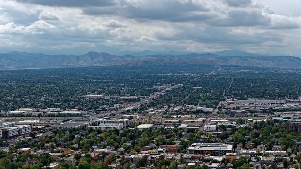 Aerial view of the Cherry Creek area featuring urban development residential neighborhoods and lush trees with the Rocky Mountains in the background in Denver Colorado United States. Aerial view of the Cherry Creek area featuring urban development residential neighborhoods and lush trees with the Rocky Mountains in the background in Denver Colorado United States.