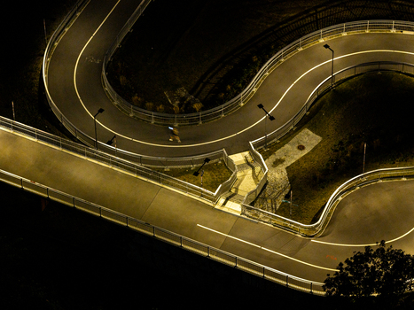 Aerial view of the illuminated Hilde Archenhold Brucke pedestrian bridge at night with winding paths and a person walking Berlin Berlin Germany. Aerial view of the illuminated Hilde Archenhold Brucke pedestrian bridge at night with winding paths and a person walking Berlin Berlin Germany.