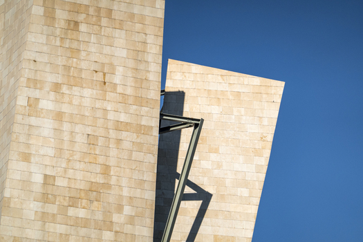 View of the Guggenheim Museum Bilbao showing modern limestone walls and sharp geometric angles against a clear blue sky Bilbao Euskadi Spain. View of the Guggenheim Museum Bilbao showing modern limestone walls and sharp geometric angles against a clear blue sky Bilbao Euskadi Spain.