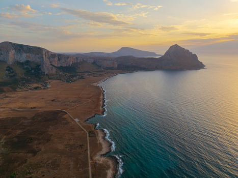 Aerial view of the rugged coastline of Sicily near Palermo with dramatic cliffs golden hour light and turquoise sea waters Palermo Sicily Italy. Aerial view of the rugged coastline of Sicily near Palermo with dramatic cliffs golden hour light and turquoise sea waters Palermo Sicily Italy.