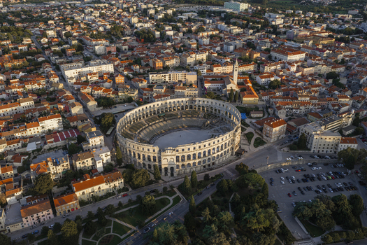 Aerial view of Pula Arena surrounded by historic rooftops and urban cityscape in Pula Istarska zupanija Croatia. Aerial view of Pula Arena surrounded by historic rooftops and urban cityscape in Pula Istarska zupanija Croatia.