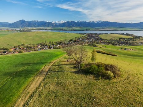 Aerial view of the village with green hills Liptovska Mara reservoir and the Tatra Mountains in Liptovsky Trnovec Zilina Region Slovakia.