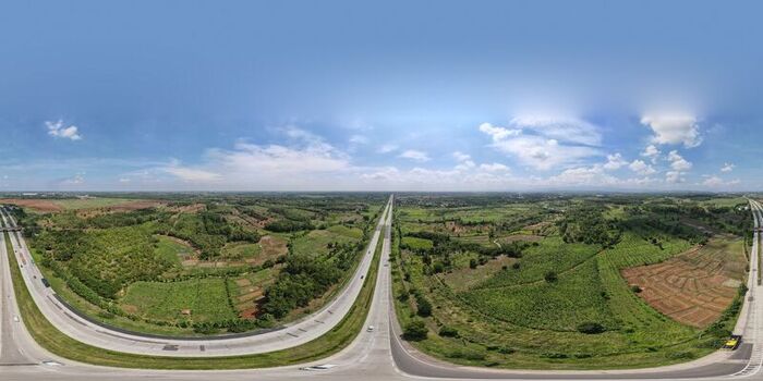 Aerial view of the Cipularang Toll Road winding through the lush green agricultural fields and rural landscape of Cipeundeuy West Java Indonesia. Aerial view of the Cipularang Toll Road winding through the lush green agricultural fields and rural landscape of Cipeundeuy West Java Indonesia.