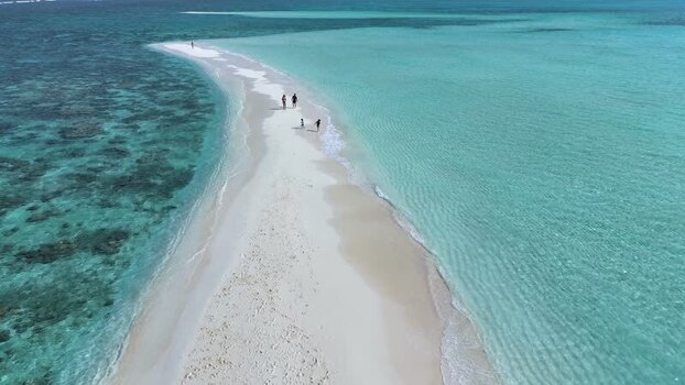 Aerial view of people walking on a white sandbank in the ocean Maldives. Aerial view of people walking on a white sandbank in the ocean Maldives.