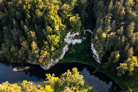Aerial view of Teufelsbrucke stone bridge spanning white limestone cliffs above the Danube river surrounded by lush green forest in Inzigkofen Baden Wurttemberg Germany. Aerial view of Teufelsbrucke stone bridge spanning white limestone cliffs above the Danube river surrounded by lush green forest in Inzigkofen Baden Wurttemberg Germany.