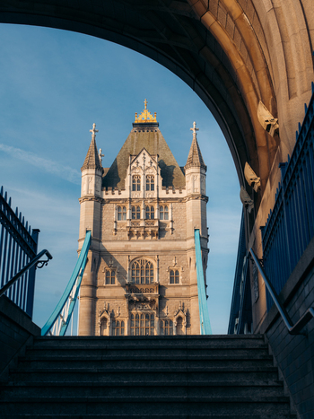 London United Kingdom 20 June 2025 View of the Tower Bridge s majestic stone tower framed by a stone archway and the blue sky. London United Kingdom 20 June 2025 View of the Tower Bridge s majestic stone tower framed by a stone archway and the blue sky.