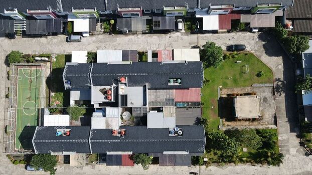Aerial view of Jakasampurna residential area featuring rooftops a small sports court and green spaces in Bekasi Barat West Java Indonesia. Aerial view of Jakasampurna residential area featuring rooftops a small sports court and green spaces in Bekasi Barat West Java Indonesia.