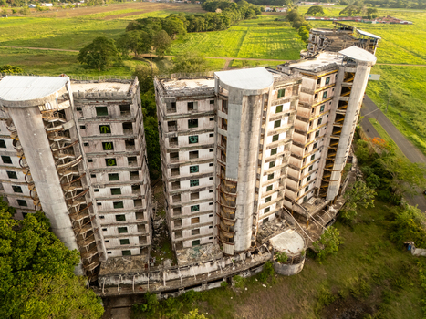 Aerial view of the abandoned concrete structures of the Sonesta One Resort surrounded by lush green fields and trees in Jaco Provincia de Puntarenas Costa Rica. Aerial view of the abandoned concrete structures of the Sonesta One Resort surrounded by lush green fields and trees in Jaco Provincia de Puntarenas Costa Rica.