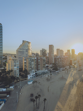 Aerial view of coastal city skyline with modern high rise buildings and sandy beach during golden hour in Calp Valencian Community Spain. Aerial view of coastal city skyline with modern high rise buildings and sandy beach during golden hour in Calp Valencian Community Spain.