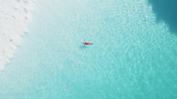 Aerial view of woman floating in turquoise water Greenland. Aerial view of woman floating in turquoise water Greenland.