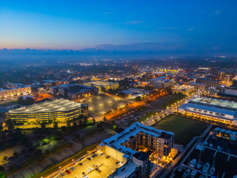 Aerial view of Riverfront Park and the illuminated cityscape of Wilmington at twilight featuring the marina parking structures and urban architecture in Wilmington North Carolina United States.