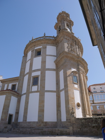 View of the Santuario de la Virgen Peregrina with its distinctive Baroque architecture stone detailing and clock tower under a clear blue sky in Pontevedra Pontevedra Spain.