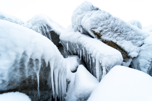 View of ice covered rocks and icicles along the frozen coastline near the Molenfeuer Sassnitz in Sassnitz Mecklenburg Vorpommern Germany.