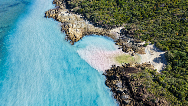 Aerial view of Chance Bay featuring turquoise waters rocky coastline and dense forest in Whitsundays Queensland Australia. Aerial view of Chance Bay featuring turquoise waters rocky coastline and dense forest in Whitsundays Queensland Australia.