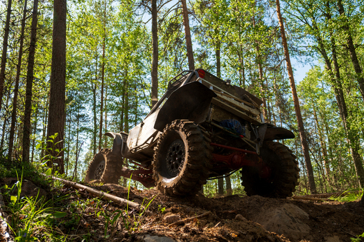View of an off road vehicle navigating through a dense pine forest near Lake Ladoga in Sortavala Respublika Kareliya Russia.
