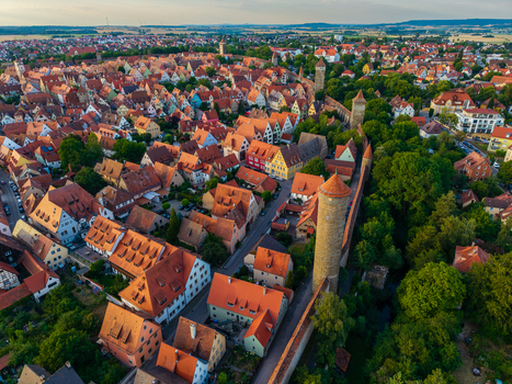 Aerial view of the historic town of Rothenburg ob der Tauber with medieval stone walls watchtowers and houses with orange rooftops in Rothenburg ob der Tauber Bavaria Germany. Aerial view of the historic town of Rothenburg ob der Tauber with medieval stone walls watchtowers and houses with orange rooftops in Rothenburg ob der Tauber Bavaria Germany.