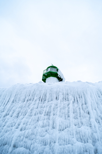 View of the Molenfeuer Sassnitz lighthouse encased in thick layers of ice and snow on a cold winter day in Sassnitz Mecklenburg Vorpommern Germany.